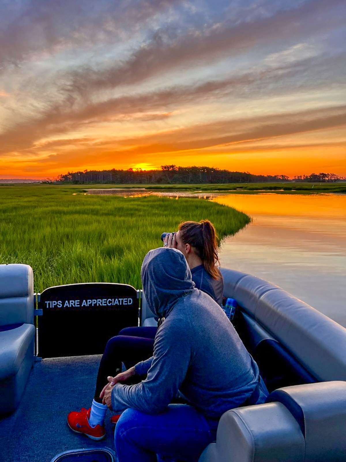 Guests enjoying a sunset boat tour through the Chincoteague marshes with Saltwater Pony Tours